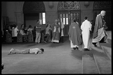 Man lying face down during church Communion.