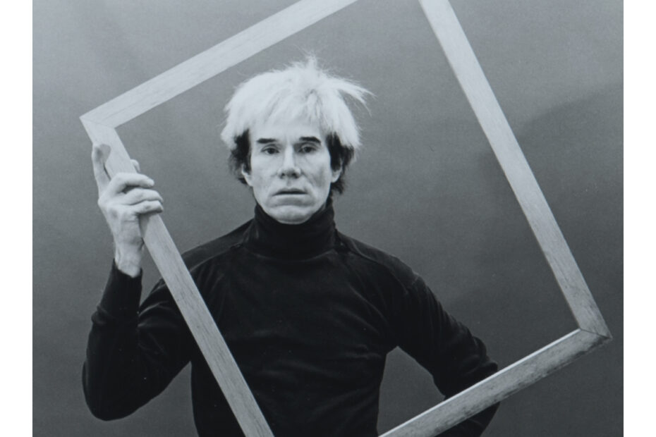 Andy Warhol holding an empty picture frame in front of himself